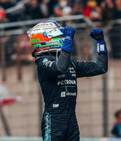 Kimi in his helmet, fist raised in celebration