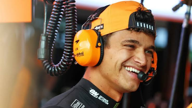 Lando laughing in the garage with his headset on